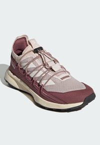 Chaussure de plein air légère en mesh mauve et beige avec des superpositions texturées. Dotée de lacets élastiques et d'une semelle rembourrée pour l'adhérence.