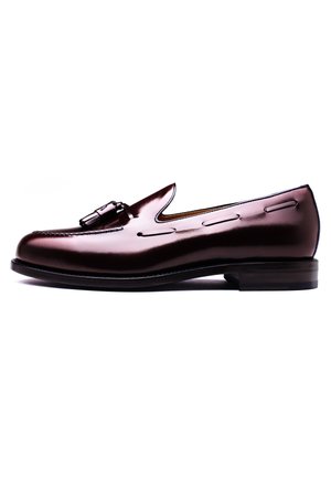 Bruine lederen loafers met een glanzende afwerking, voorzien van een opvallende decoratieve gesp en stiksels langs de zijkanten, en een ronde neus.