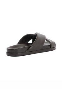 Black leather slide sandals with cross-strap design, flat sole, and smooth texture. Minimalistic style with no visible hardware or embellishments.