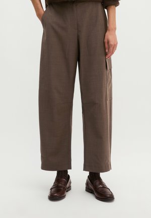 Brown wide-leg trousers with side pocket worn with dark brown socks and brown leather loafers on a person standing.