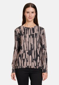 Langärmliges Oberteil mit Rundhalsausschnitt, das ein schwarz-hellrosa Pinselstrichmuster auf einem strukturierten Stoff zeigt.