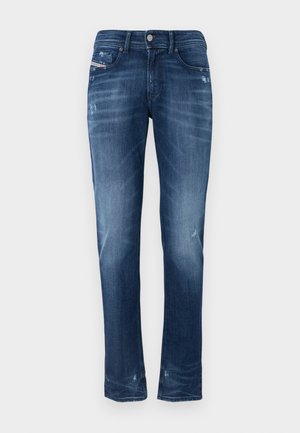 Dark blue denim jeans featuring a straight-leg design, light fading, whiskering details, and subtle distressing near the hem and pockets.