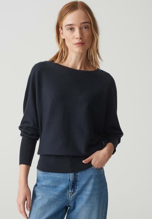 Pull en maille oversize bleu marine avec un col bateau et des manches roulées ; fabriqué dans un tissu doux, il présente un ourlet côtelé et une coupe décontractée.