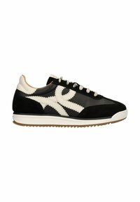Zwarte en witte atletische schoen met een bovenwerk van suede en leer, een gebogen ontwerp, contrasterende stiksels, witte veters en een rubberen zool.