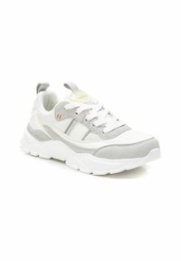 Sneaker bianchi e grigio chiaro realizzati in mesh e suede, con una suola testurizzata e dettagli colorati sulla linguetta e sui pannelli laterali.