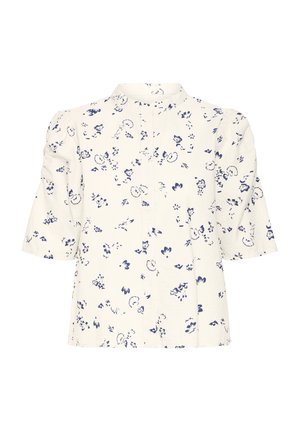 Lillelise mustriga, tekstuuriga kreemjas lühikeste varrukatega pluus siniste mustritega, kõrge kaelusega. Omaduseks on pehmed paffvarrukad ja sirge lõige.