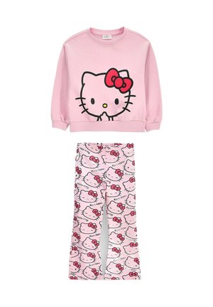 Różowy zestaw z bluzą z długim rękawem i spodniami, z dużymi i powtarzającymi się twarzami Hello Kitty z czerwonymi kokardkami na obu elementach.