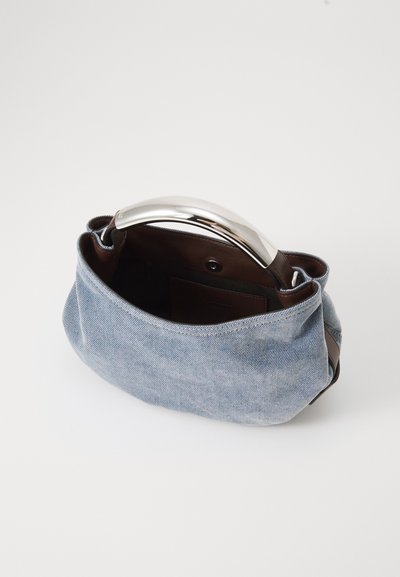 Sac en denim avec une poignée en métal argenté, offrant une texture douce et un intérieur brun avec une poche, conçu avec une forme arrondie et structurée.