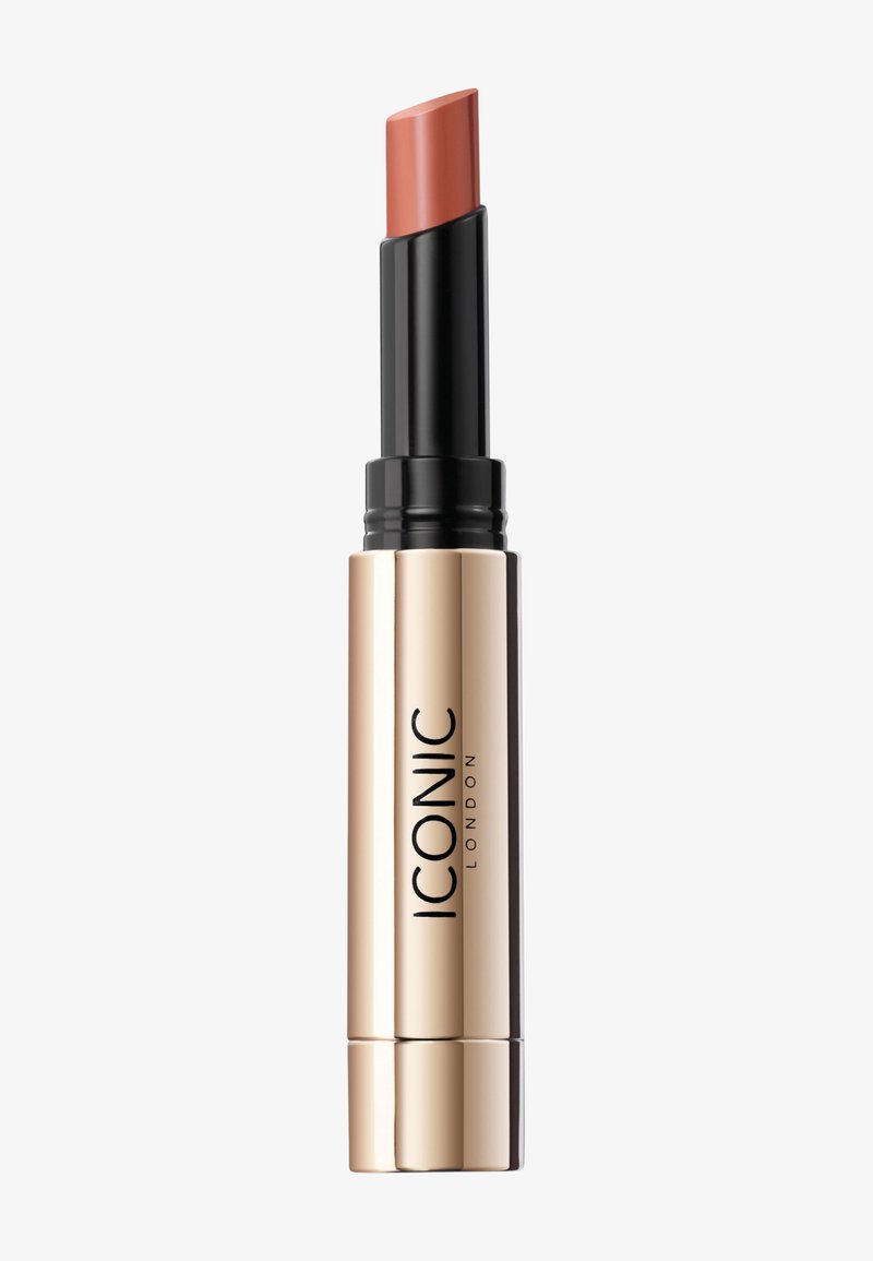 Lipstick in een zwart en gouden tube, met een draaimechanisme. De lipstick heeft een matte perzik-nude tint met een licht hellend punt.