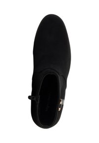 Bottine en daim noir à finition lisse, bout arrondi, fermeture éclair sur le côté, et détail en métal doré. Design simple et élégant.