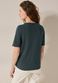 Mörkgrå kortärmad t-shirt med rund halsringning, tillverkad av mjukt tyg, med en avslappnad passform och en lätt rundad nederkant bak.