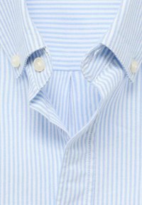 Camicia a righe blu e bianche con collo a bottoni, dotata di due bottoni al collo e una piega nel tessuto sottostante.