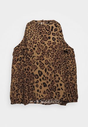 Blouse à imprimé léopard marron et noir, manches longues et découpes aux épaules sur fond blanc uni.
