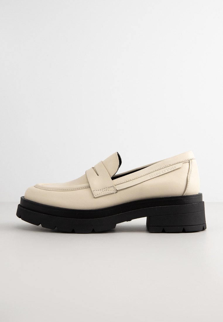Beige leren instappers met een dikke zwarte platformzool, voorzien van een klassieke pennystrap over de wreef en een mooie gladde textuur.