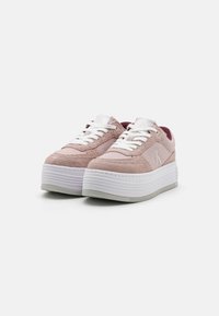 Világos rózsaszín platform sneaker, ami szarvasbőrből és szövetből készült, fehér fűzőkkel, logó részlettel és texturált fehér gumitalppal rendelkezik.