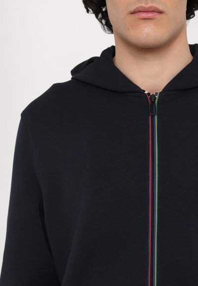 Sudadera de marina en un tejido suave, con un cierre de cremallera completo y rayas multicolores en el frente, además de un diseño clásico de capucha.