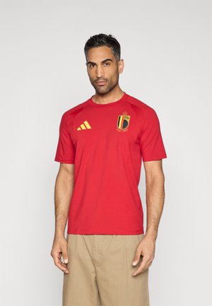 T-shirt de sport rouge à manches courtes, avec des bandes jaunes Adidas et un emblème de l'équipe nationale de Belgique sur le côté gauche de la poitrine.
