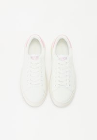 Weisse Sneakers mit einem glatten Obermaterial, pinken Akzenten an der Ferse, flachen Schnürsenkeln und einer gepolsterten Sohle. Das Markenlogo ist auf der Zunge sichtbar.