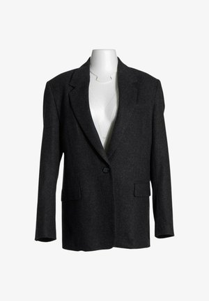 Blazer grigio antracite scuro con un solo bottone, rever con intaglio e tasche con patta su un torso di manichino bianco.