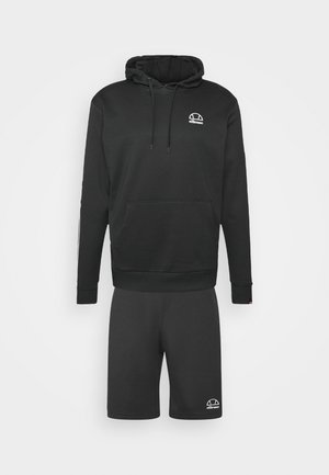 Sort hættetrøje med forlomme og snøre kombineret med matchende sorte shorts, begge med små hvide ellesse-logoer.