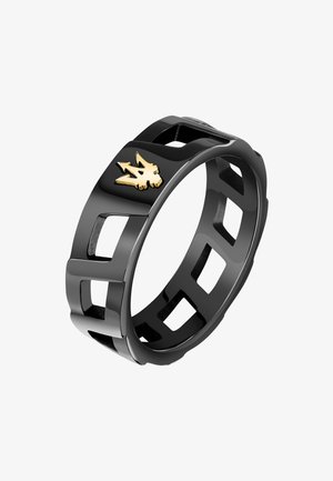 Bague en résine noire avec des formes géométriques découpées et un détail de logo doré. Sa texture lisse et ses bords arrondis offrent un design moderne.