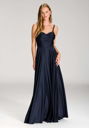 Navy blue evening gown with satin finish, slight ruching at the bodice, and embellished straps. Flowy, ankle-length silhouette with smooth texture.