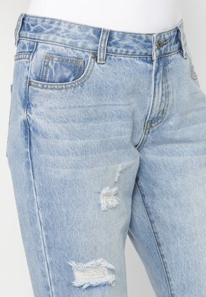Jeans in denim azzurro chiaro con design classico a cinque tasche, dettagli strappati e toppe sfilacciate sulle ginocchia.