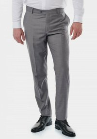 Pantalon gris en tissu léger, avec une coupe slim, devant plat et plusieurs poches, assorti à des chaussures noires à lacets.