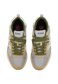 Baskets avec un mélange de mesh gris clair et de daim beige. Lacets verts, col rembourré et logo rouge sur la semelle noire. Semelle en caoutchouc.