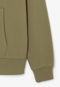 Felpa verde con una texture liscia, polsini a costine e tasca a marsupio. Presenta un orlo arrotondato e una vestibilità casual.