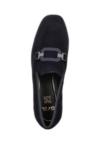 Scarpa slip-on in camoscio blu navy con suola piatta. Presenta un elegante facciale rettangolare nero sulla parte anteriore e una superficie liscia e texture.
