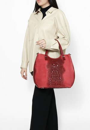 Rode leren handtas met een geperforeerd krokodillenpatroon, gebogen vorm en dubbele handvaten. Versterkt door zilveren hardwaredetails.