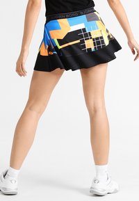 Černá sukně s barevnými geometrickými vzory v modré, oranžové a bílé barvě. Má široký pas s logem "BJÖRN BORG". Rozšířený střih.