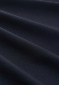 Tissu lisse de couleur bleu marine foncé avec des plis subtils, montrant une texture fine et une finition douce et mate.