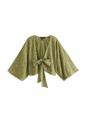 Bluzka w stylu kimono w oliwkowej zieleni z szerokimi rękawami, kwiatową haftą, srebrnymi ćwiekami i dużą kokardą z tyłu.