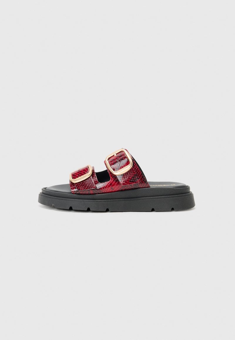 Rød slangeskinn mønster sandal med to justerbare metallspenner på en svart plattformsåle, med en glatt tekstur og formet fotseng.