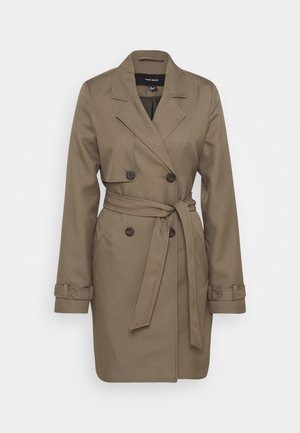 Trench-coat marron croisé avec larges revers, détails boutons, ceinture à la taille et bracelets de manches, présenté sur un fond uni.