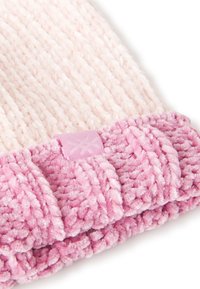 Cappello lavorato a maglia con una morbida e pelosa texture, di colore rosa chiaro con un risvolto a coste di un rosa più scuro. Include un piccolo etichetta decorata.