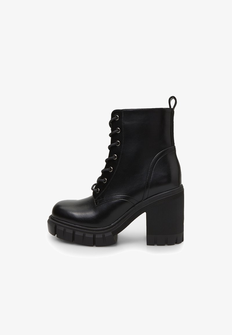 Bottine en cuir noir à la cheville avec talon haut épais, lacets à l'avant, semelle épaisse à crampons et languette à l'arrière.