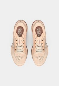 Tenisi sport de culoare piersică deschisă, cu un material superior din plasă respirabilă, șireturi și o talpă cu amortizare. Prezintă un logo Nike reflective și accente texturate.