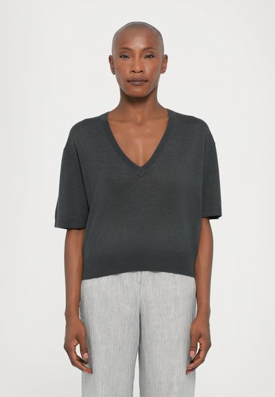 Pull-over gris foncé à manches courtes et en V, avec une coupe décontractée. Texture lisse, en tricot, et accents côtelés au niveau de l'encolure et de l'ourlet.