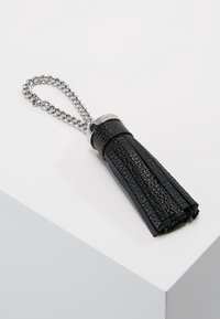 Portachiavi in pelle nera con design frangiato, caratterizzato da una catena argentata lucida e un accento metallico circolare nella parte superiore.