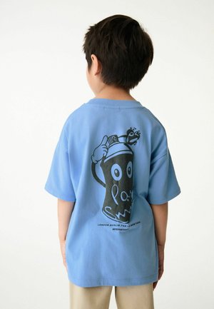 Himmelblå bomulds t-shirt med en sort spraydåse grafik på ryggen, kompletteret med legende detaljer og tekst i bunden, kortærmet.