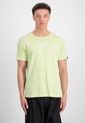 Hellgrünes T-Shirt mit kurzen Ärmeln aus Baumwolle, das einen weißen Logo-Druck auf der Brust und schwarze Akzente an den Ärmeln aufweist.