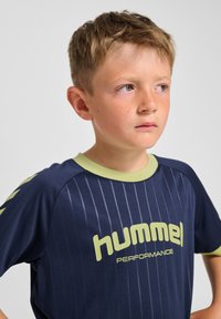 Marinblå sportströja med vertikala ränder, korta ärmar och ljusgröna detaljer. Har "hummel"-logotypen tydligt framtill.