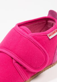 Różowe buty z tkaniny o teksturowanej powierzchni, z rzepem, wyściełanym kołnierzem i subtelnym gradientowym obcasem. Gumowa podeszwa zapewniająca dobrą przyczepność.