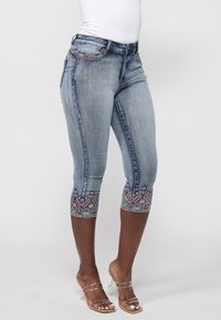 Helle blaue Denim-Capri-Jeans mit dekorativen gestickten Akzenten am Saum. Verfügt über standardmäßige Taschen und eine normale Hüfthöhe.