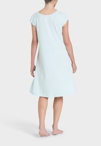 Camicetta da notte azzurro chiaro a maniche corte con scollatura rotonda, silhouette svasata e tessuto morbido, caratterizzata da una texture liscia e senza motivi visibili.