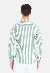 Camicia a maniche lunghe a righe verdi e bianche in un tessuto leggero, con colletto alla cinese e polsini abbottonati.