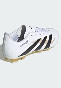 White soccer cleat with black stripes and gold accents, textured upper, lace-up design, and molded rubber outsole. Model: Predator 1994.